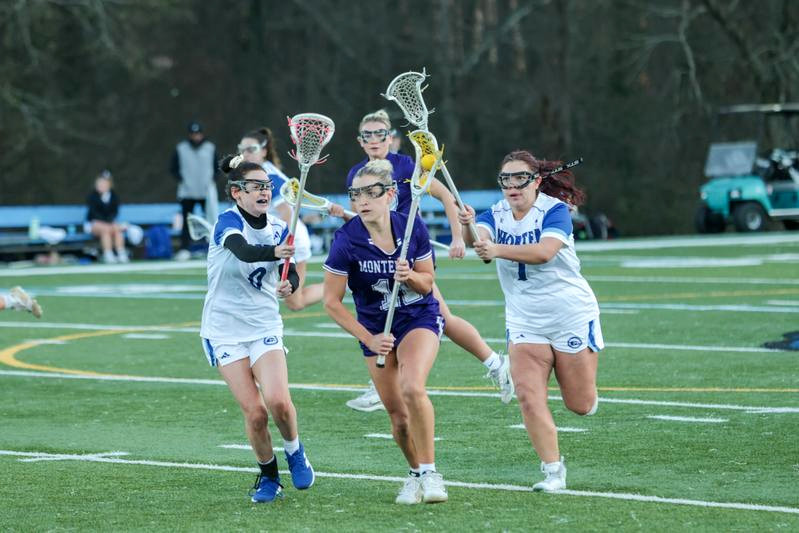 Lacrosse player leading attack between defenders