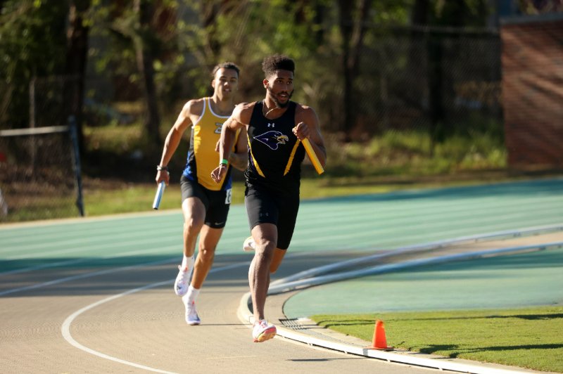 Montevallo student leading the relay race holding a baton