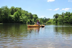 Student paddling in a canoe at the University Lake
