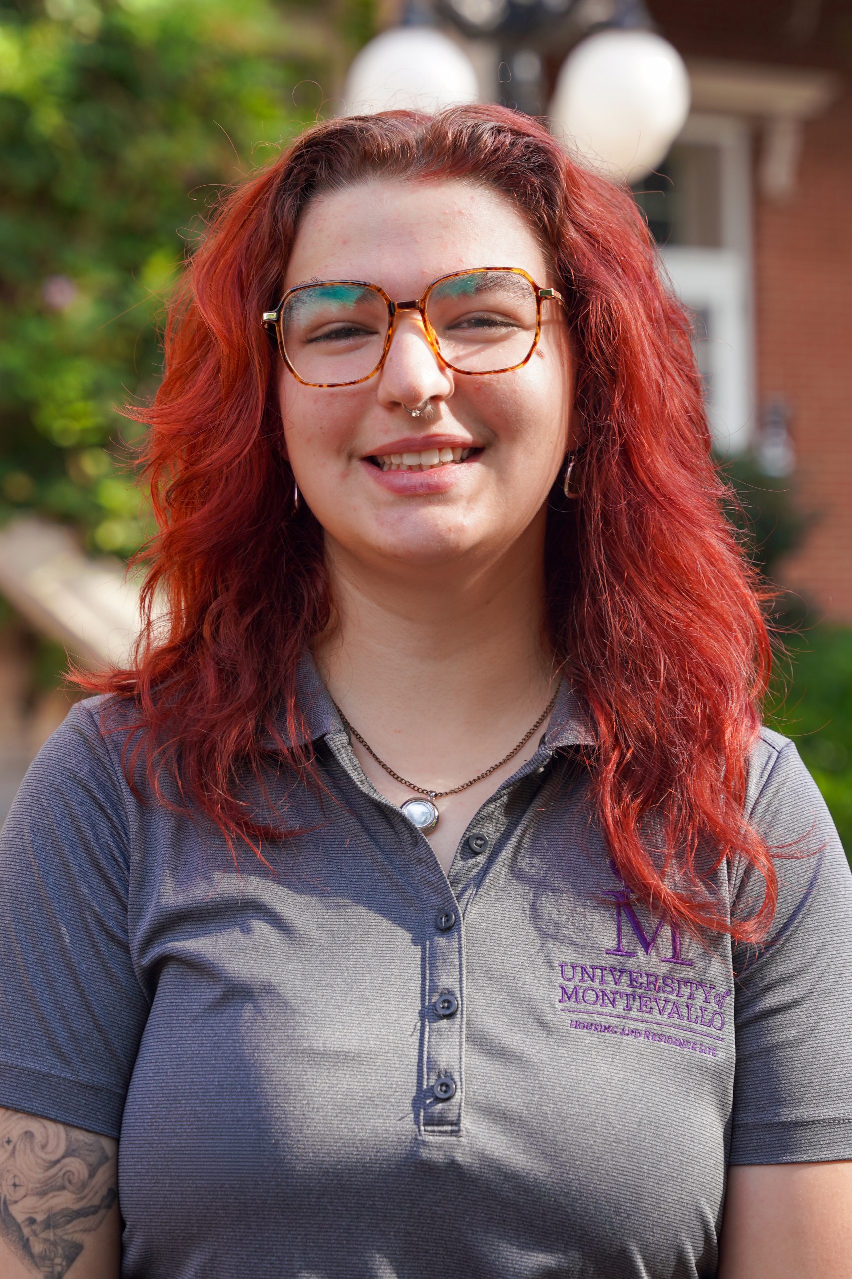 Headshot of Alivia Gadbaw - a female with a grey shirt, red hair and eyeglasses