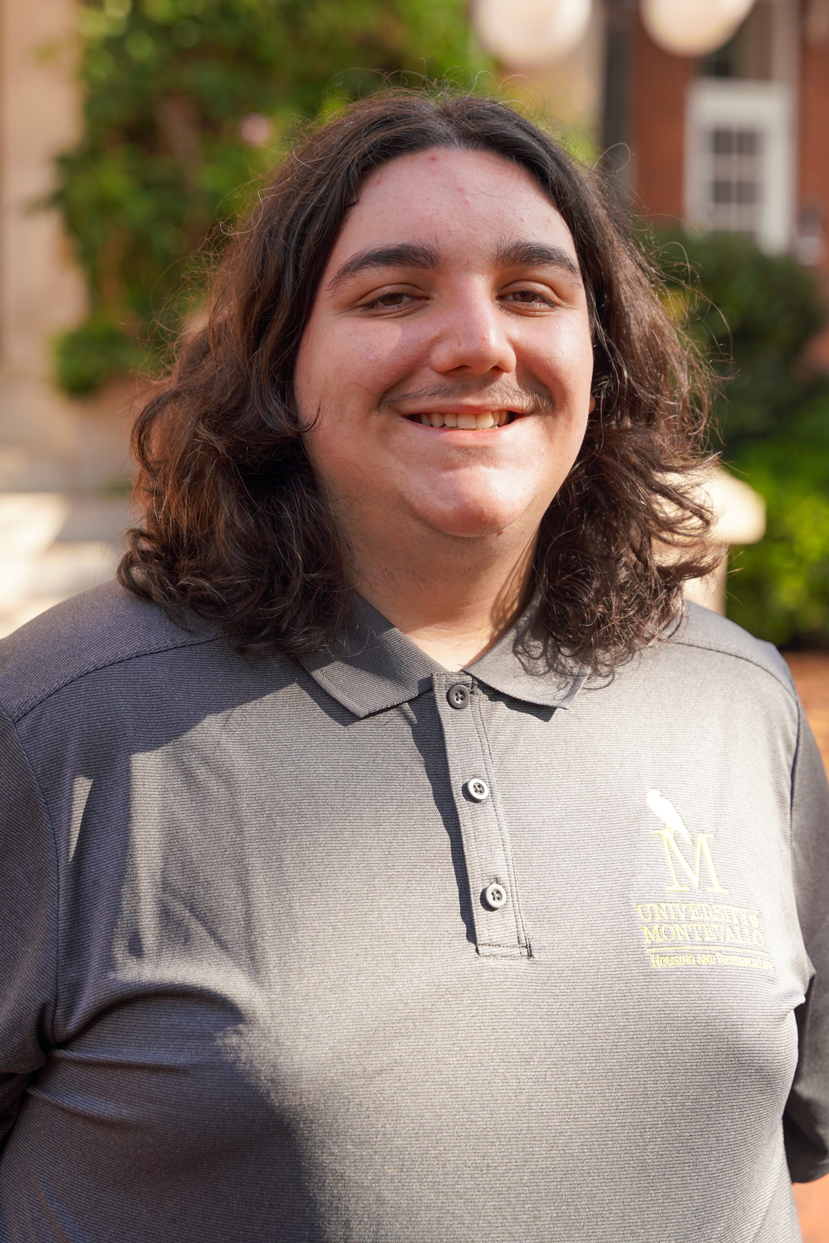 Headshot of Ryan Spanier - male with grey shirt and brown curly hair